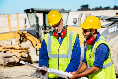 Construction-workers-examining-blueprint-at-quarry