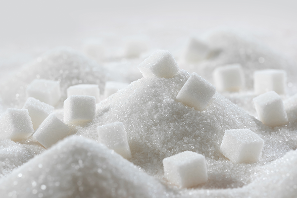Pile of white granulated sugar and sugar cubes